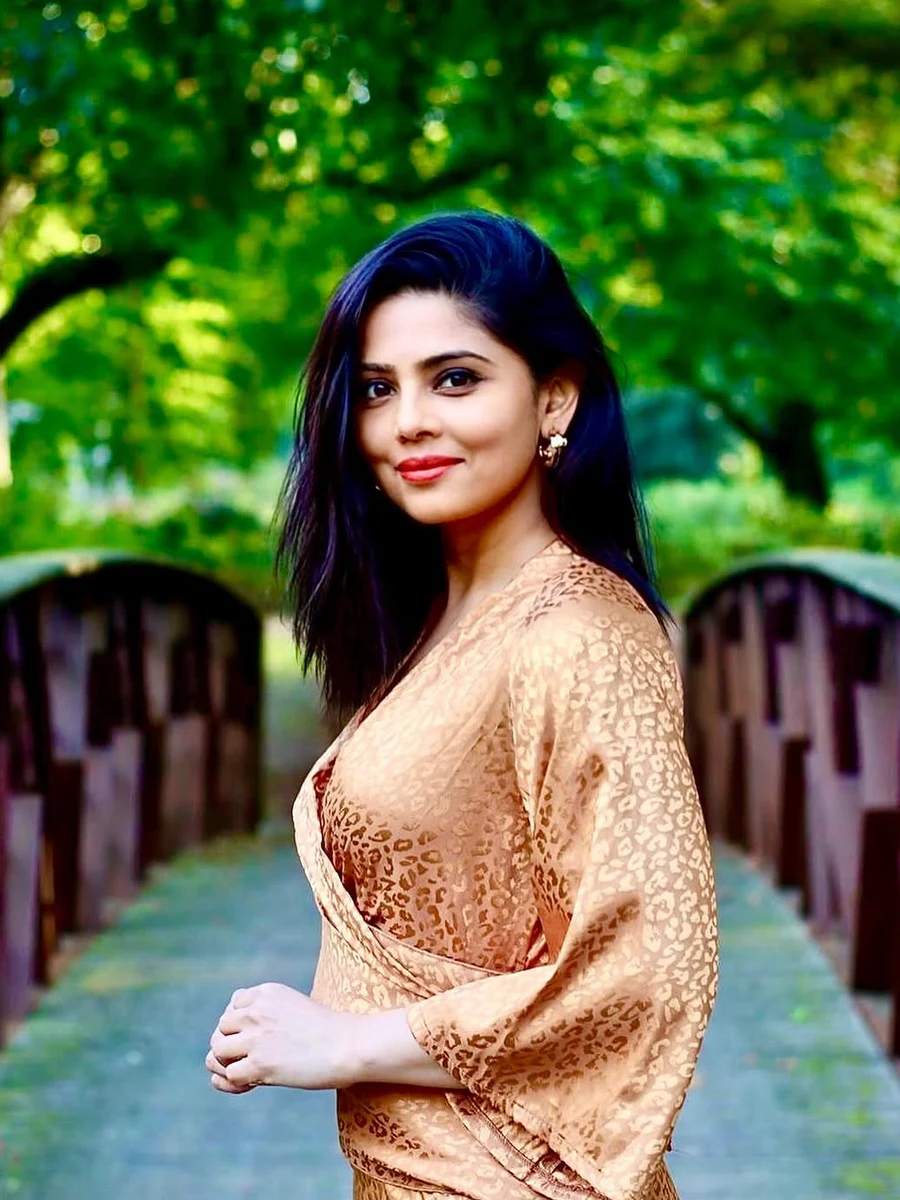 Shruti Mishra standing on a wooden bridge in a garden